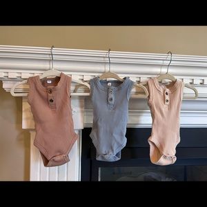 Gender neutral tank onesies with button detail.